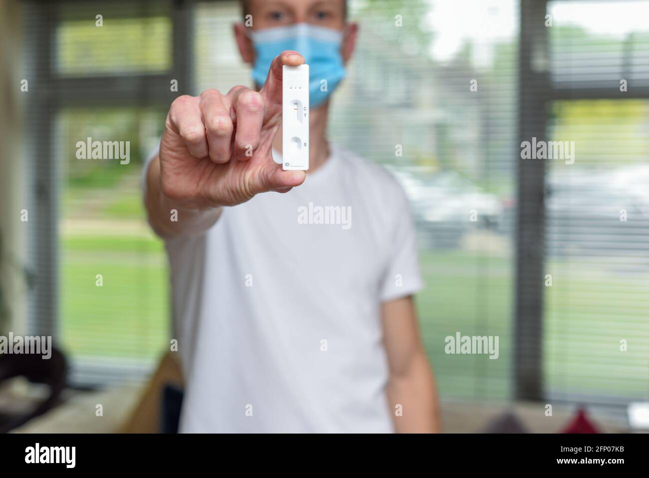 Mann hält einen Covid-19-Heimtest, der einen negativen Test zeigt Ergebnis für Coronavirus Stockfoto
