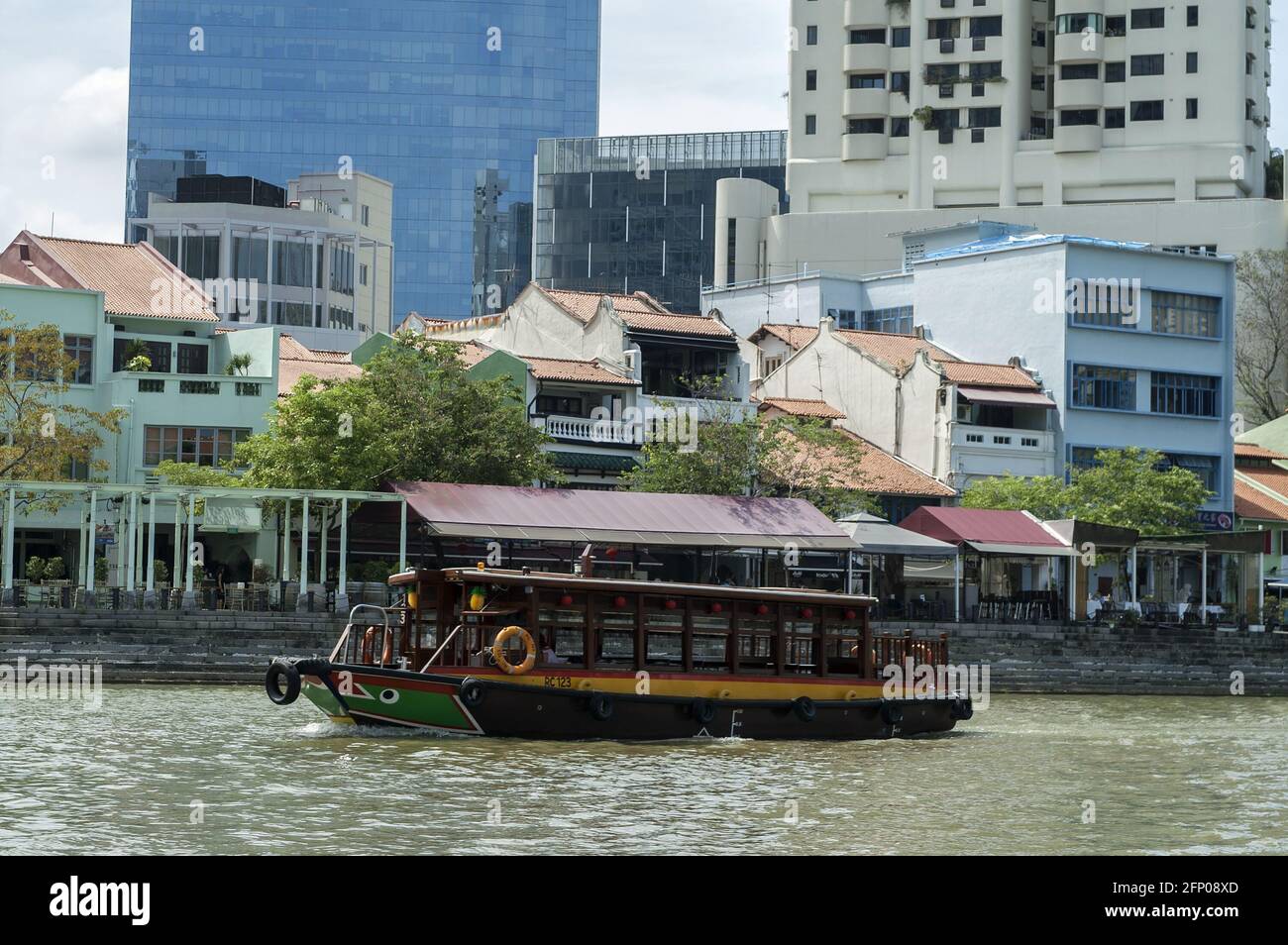 Singapur, Singapur, Asien, Asien; EIN Kreuzfahrtboot auf dem Singapore River mit Küstengebäuden im Hintergrund. Ausflugsschiff auf dem Fluss. Stockfoto