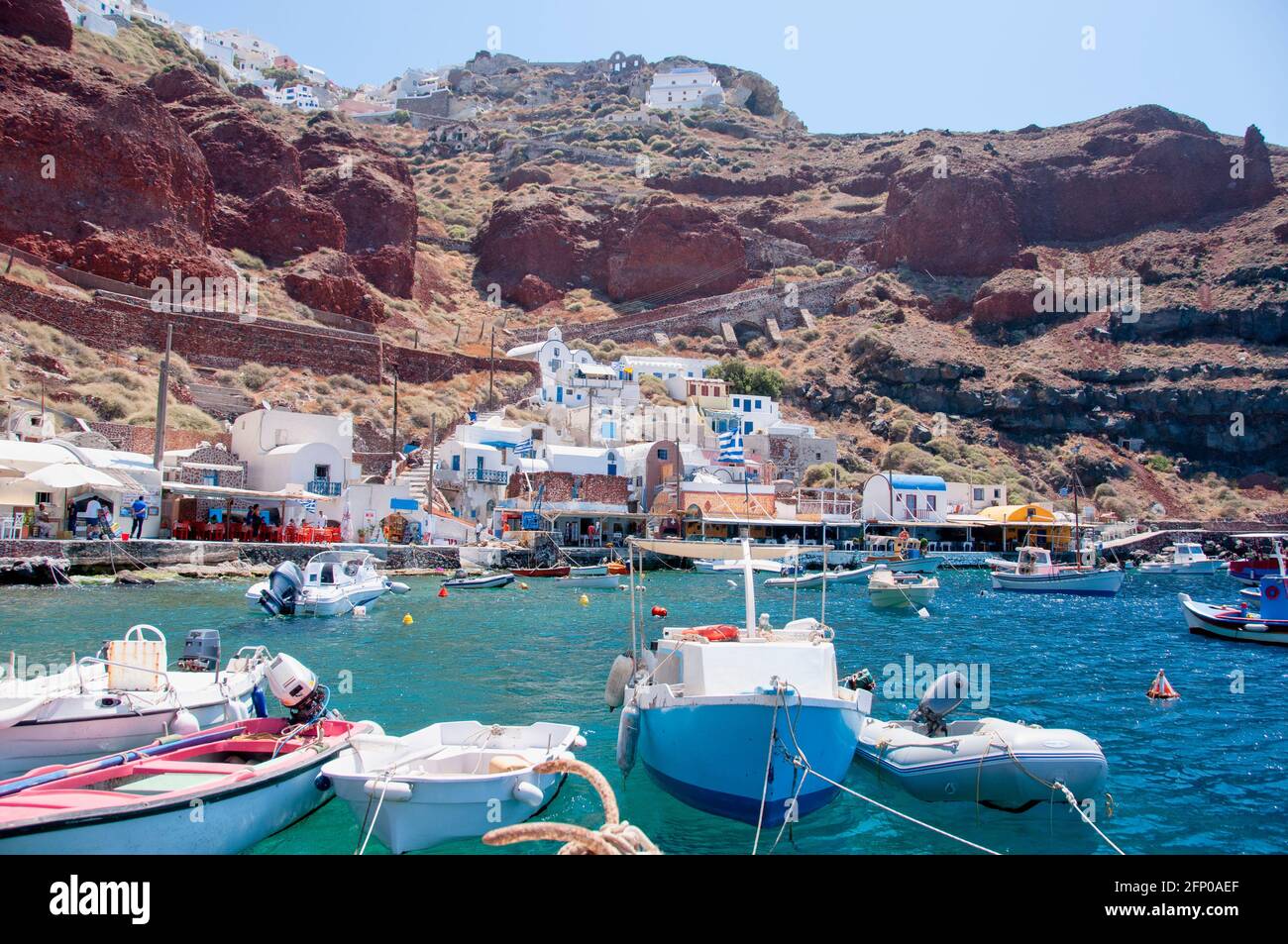 Der Hafen von Amoudi liegt in der Bucht der Insel Santorini, Griechenland. Der Yachthafen ist eingebettet in die hohen vulkanischen Klippen mit Restaurants, Bars Stockfoto