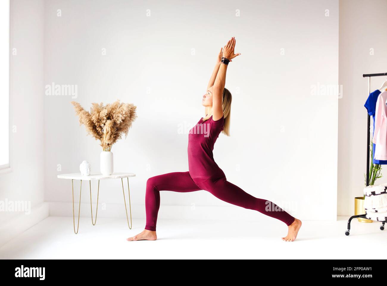 Junge Frau in Yoga-Pose und meditiert im weißen Raum Stockfoto