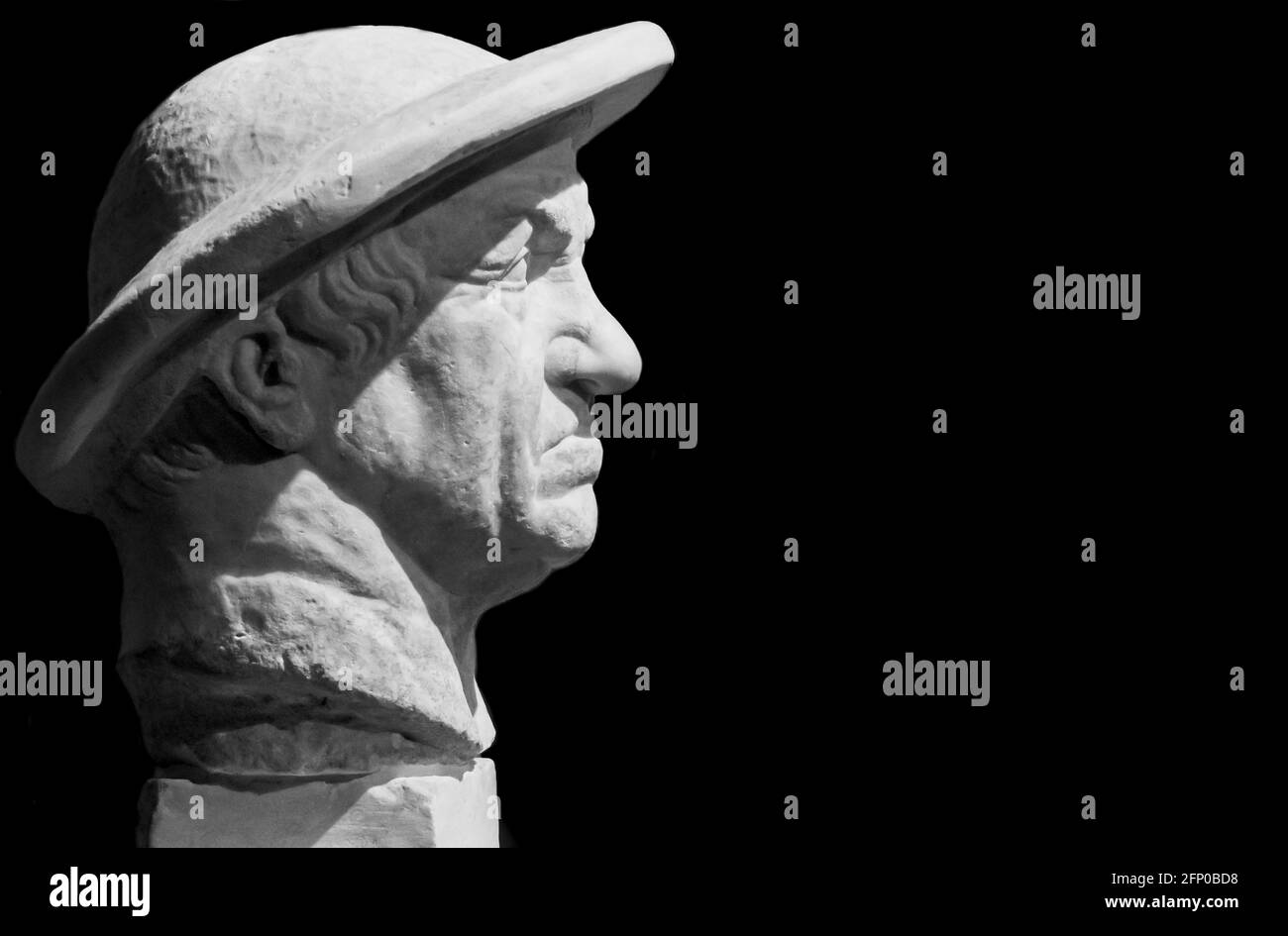 Schwarzweiß-Foto in Nahaufnahme auf mürrem Gesicht in Profil der Statue eines älteren Mannes mit Hut Stockfoto