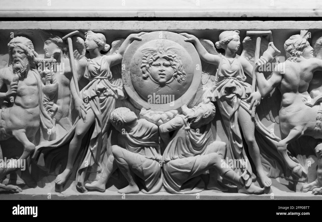 Schwarz-Weiß-Foto von alten römischen Skulpturen geschnitzt auf Eine Marmorwand, die eine mythologische Schlacht zeigt Stockfoto