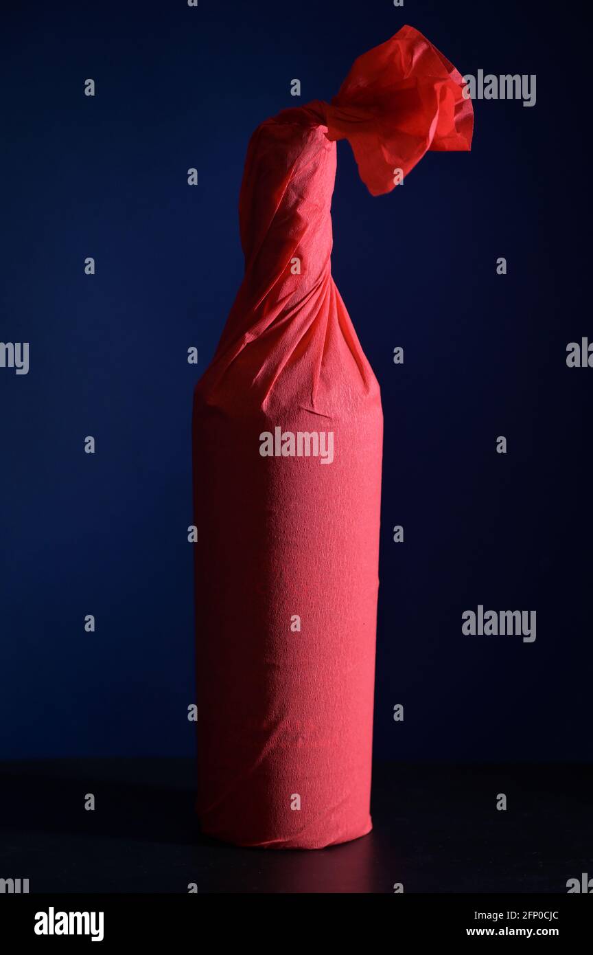 Rotpapier Wrap Weinflasche Shoot im Studio Stockfoto