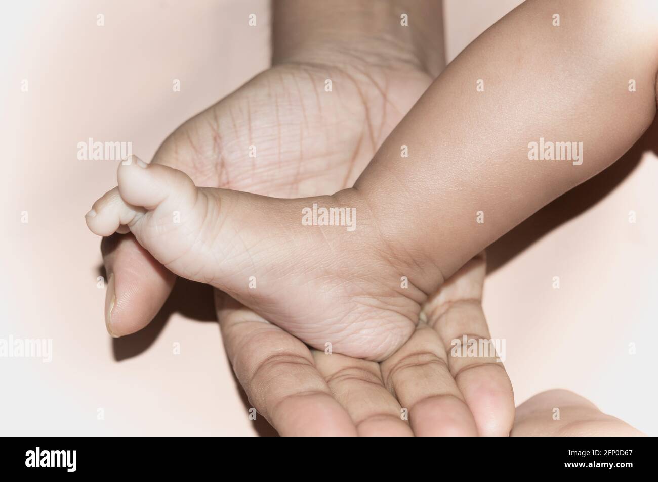 Neugeborener Baby-Fuß auf der väterlichen Handfläche. Füße eines kleinen Kleinkindes in der Handfläche seines Vaters. Nahaufnahme. Vaterschaft Elternschaft Kinderbetreuung Hintergrund. Stockfoto