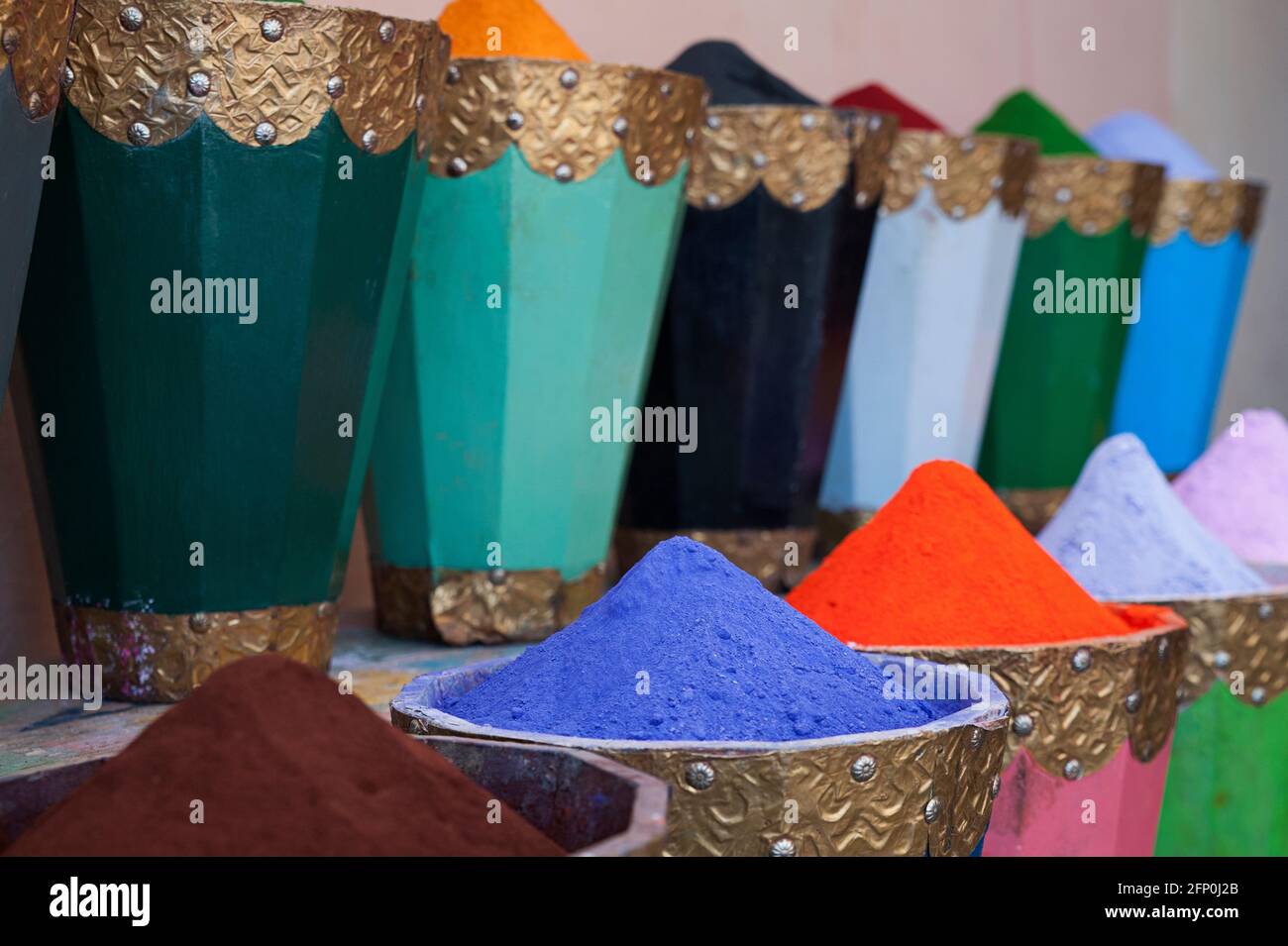 Leuchtendes, farbenfrohes Pigmentpulver oder typischer Mineralfarbstoff fein gemahlen und in robusten traditionellen Holzkisten in der Medina gelagert Stockfoto