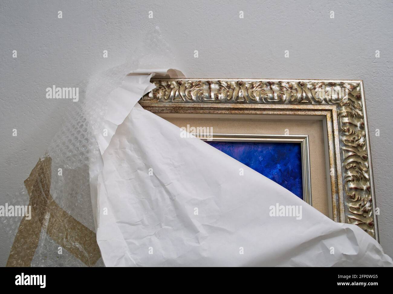 Unverpacktes Gemälde, das sich an die Wand lehnt Stockfoto