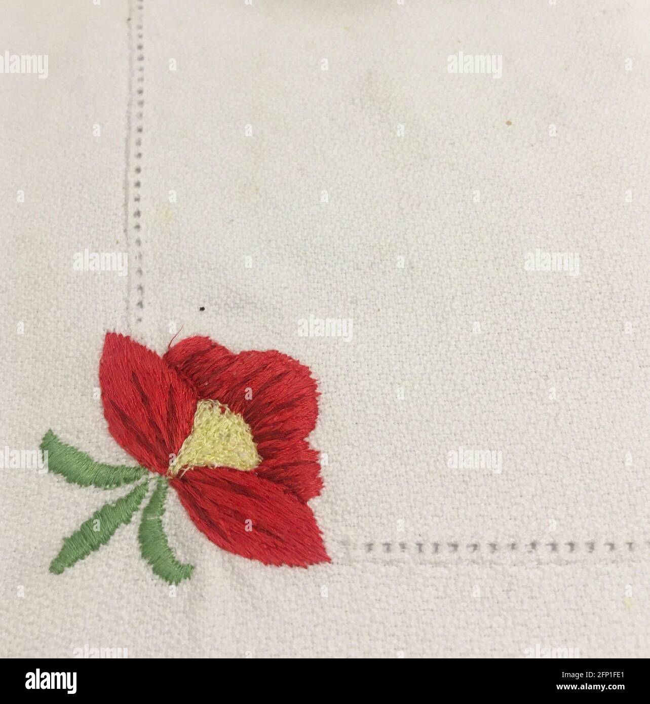 Rote Blume auf einer Tischdecke gestickt Stockfoto