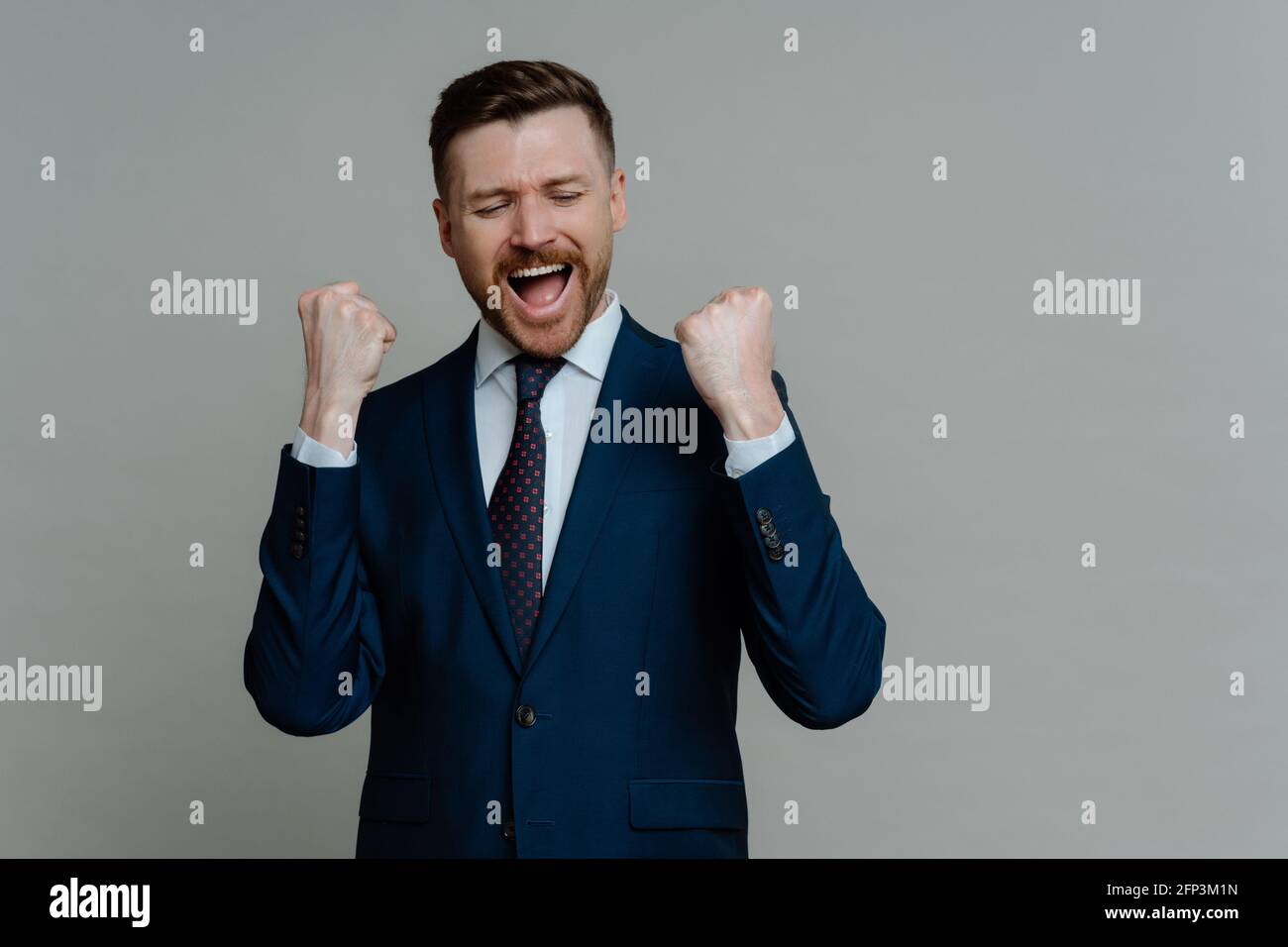 Aufgeregter professioneller Geschäftsmann, der schreit und den Triumph feiert Stockfoto