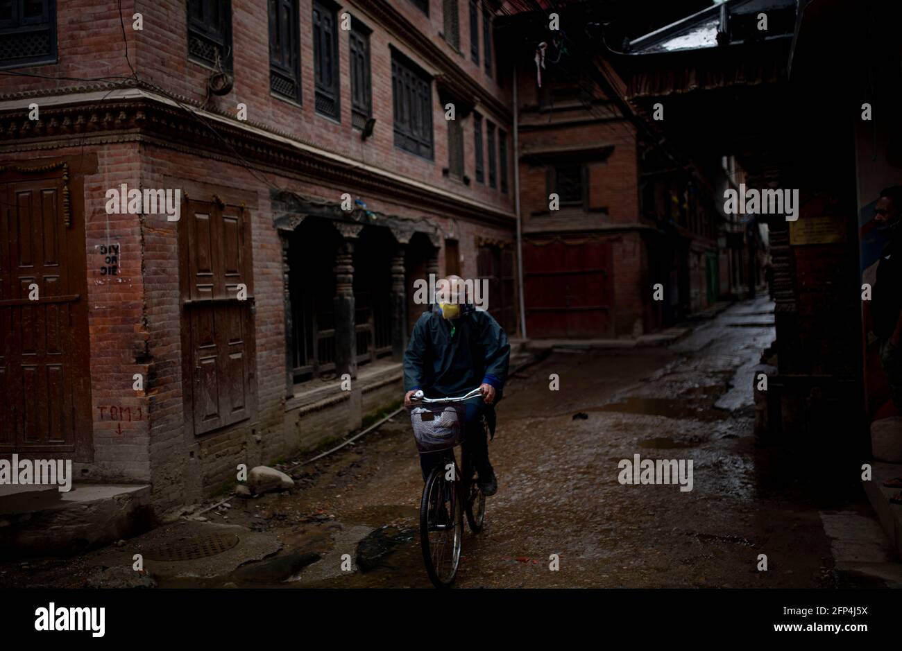 (210520) -- LALITPUR, 20. Mai 2021 (Xinhua) -- EIN Mann mit Schutzmaske Pedale sein Fahrrad auf einer leeren Straße während des Verbots von der Regierung auferlegt, die Ausbreitung der COVID-19 in Lalitpur, Nepal, am 20. Mai 2021 zu kontrollieren. (Xinhua/Sulav Shrestha) Stockfoto