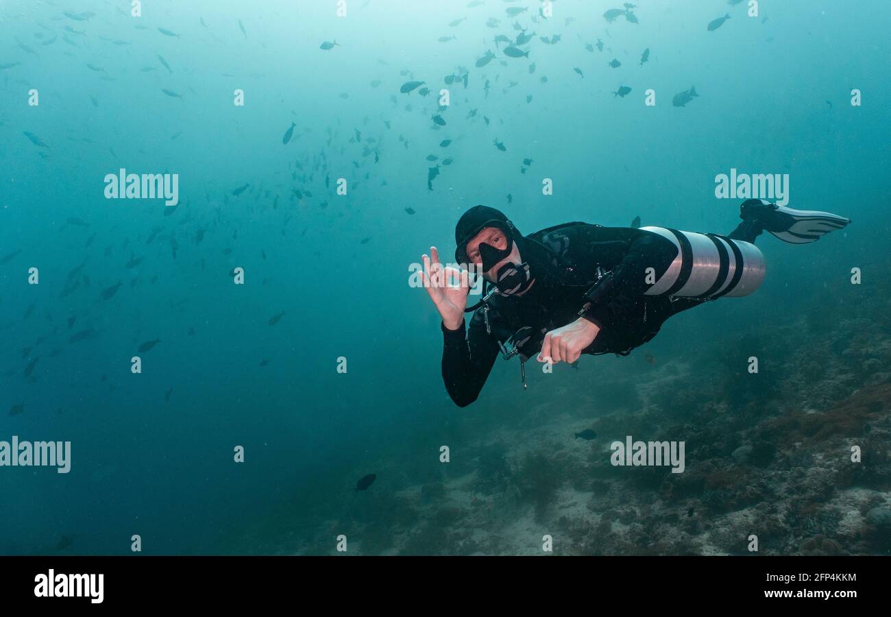 taucher mit seitlich montierten Lufttanks in Raja Ampat, die Hand geben Signal Stockfoto