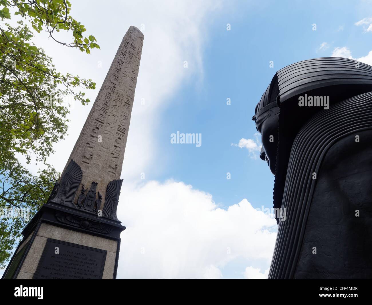 London, Greater London, England - 18 2021. Mai: Cleopatras Needle, ein Eqyption Obelisk und eine bronzene Spinx-Statue in der Nähe von Embankment Gardens. Stockfoto
