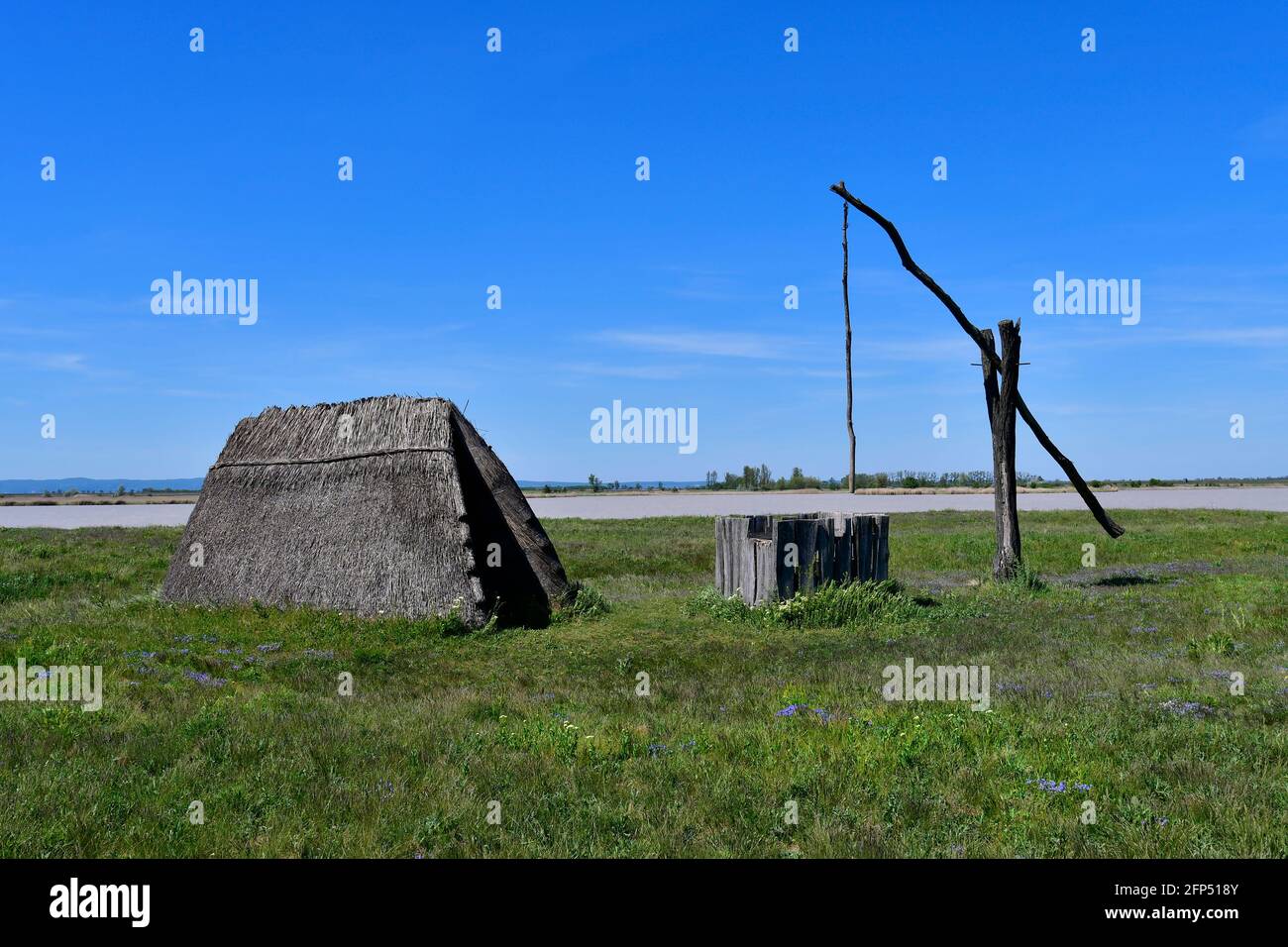 Österreich, traditioneller alter Ziehbrunnen und Jurte aus Stroh am winzigen See, Teil der eurasischen Steppe im Burgenland und Teil der internationalen Union für Kontra Stockfoto