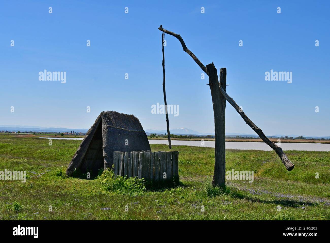 Österreich, traditioneller alter Ziehbrunnen und Jurte aus Stroh am winzigen See, Teil der eurasischen Steppe im Burgenland und Teil der internationalen Union für Kontra Stockfoto