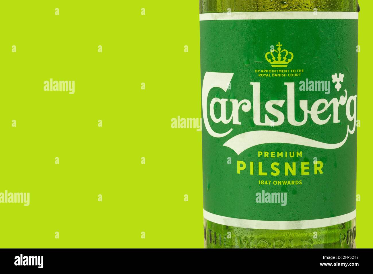 Warschau, Polen - 20. Mai 2021: Frisches carlsberg-Bier in einer Glasflasche aus der Nähe. Hintergrund mit Platz für Text. Auf grünem Hintergrund isolieren Stockfoto