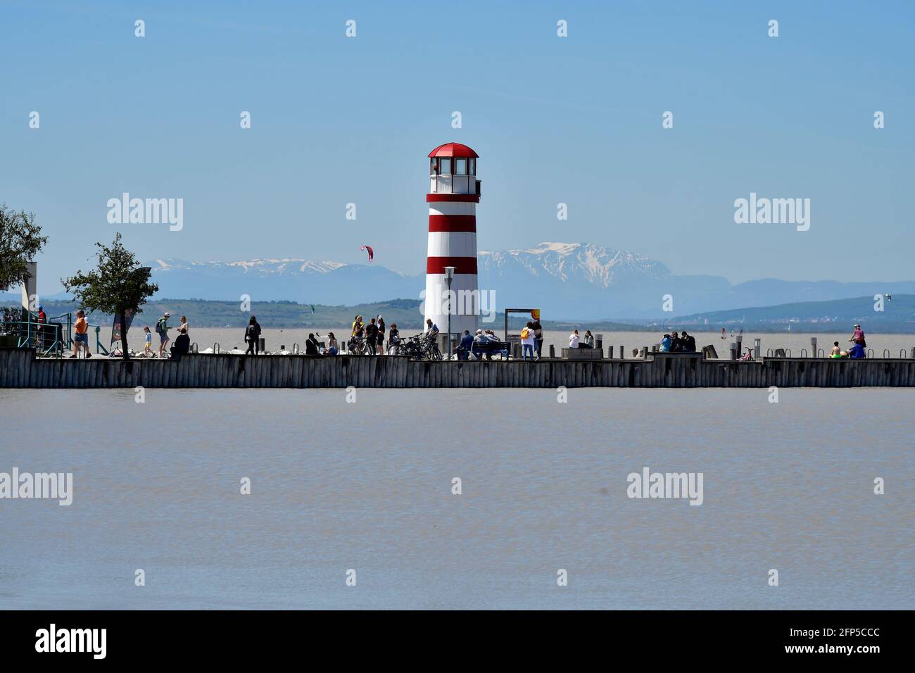 Podersdorf, Österreich - 029. Mai 2021: Nicht identifizierte Personen auf Anlegesteg und Leuchtturm im Seebad am Neusiedlersee, einem bevorzugten Reisedesti Stockfoto