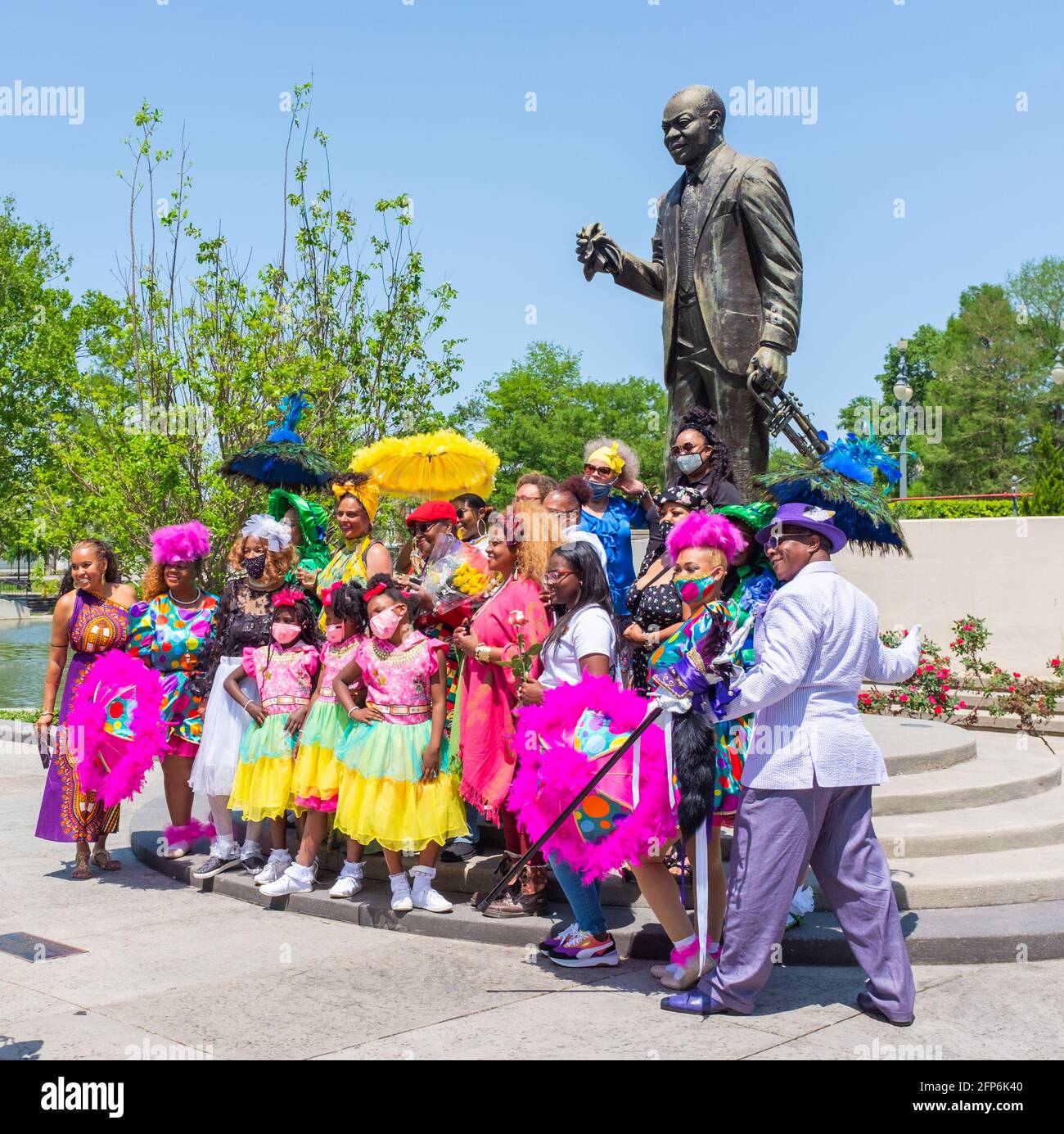Baby Dolls Marching Club posiert vor Louis Armstrong Statue im Armstrong Park vor der Feier des Lebens von Alfred „Uganda“ Roberts Stockfoto