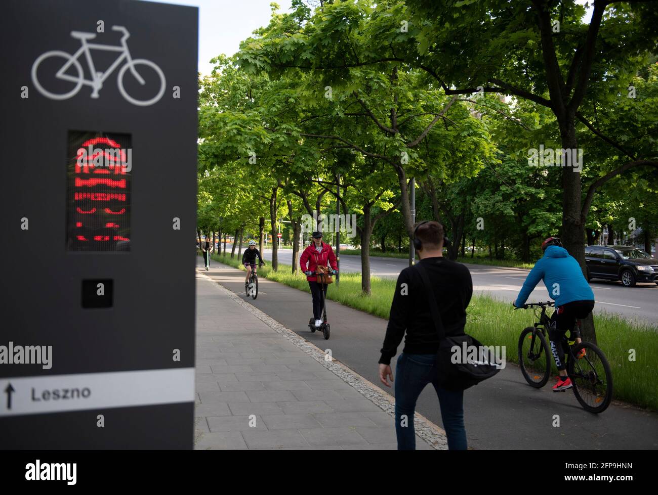 Warschau, Warschau, Polen. Mai 2021. Eine Frau fährt am 20. Mai 2021 in Warschau, Polen, mit einem E-Scooter, während andere mit dem Fahrrad fahren. Das polnische parlament verabschiedete ein Gesetz, das die Nutzung von E-Scootern in Polen regelt und eine Geschwindigkeitsbegrenzung auf 20 km pro Stunde und eine ausschließliche Nutzung auf Radwegen einführt. Wenn kein Radweg verfügbar ist, können E-Scooter auf dem Bürgersteig verwendet werden, ohne die Gehgeschwindigkeit zu übertreffen. Es ist auch verboten, während des Fahrens und nach dem Alkoholkonsum am Telefon zu telefonieren. Quelle: Aleksander Kalka/ZUMA Wire/Alamy Live News Stockfoto