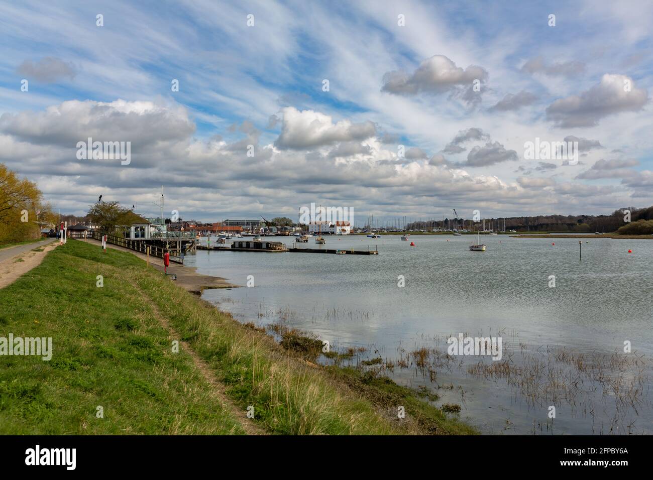 Blick den Fluss Deben hinunter zur Gezeitenmühle hinein Woodbridge bei Flut mit einer Vielzahl von Booten vor Anker Im Fluss an einem Frühlingstag Stockfoto