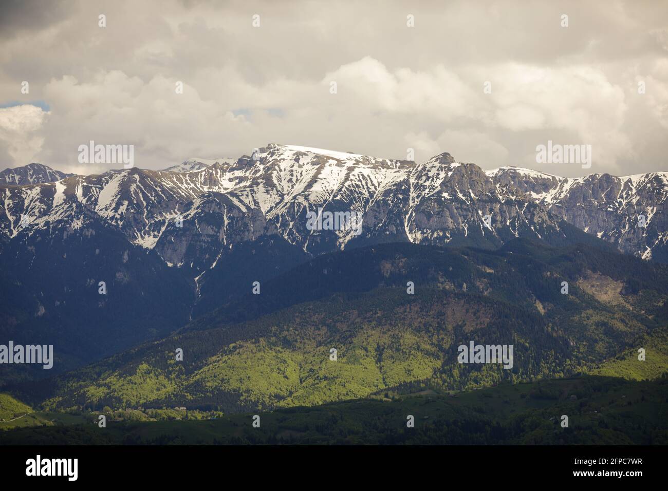 Heavy clouds over the Bucegi mountains in Romania during a spring day, as seen from the hills of Pestera village. Stockfoto