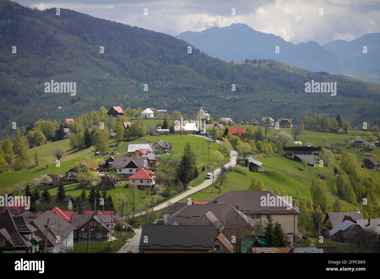 Pestera, Rumänien - 14. Mai 2021:Hügellandschaft mit Dörfern und Wäldern in Siebenbürgen, Rumänien, mit den Bucegi-Bergen im Hintergrund. Stockfoto