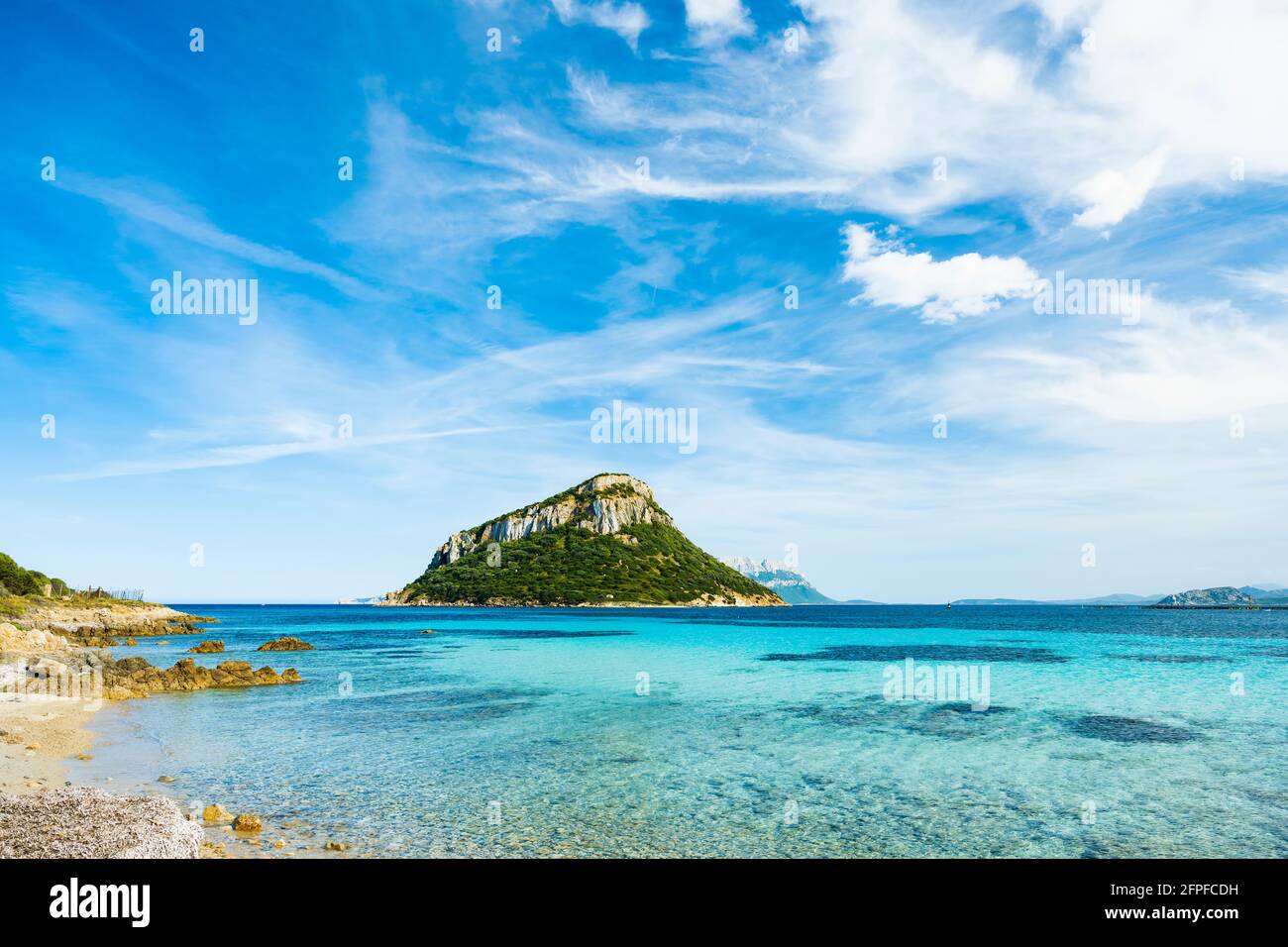 Sonniger Blick auf die Insel Figarolo, die an einem sonnigen Tag von einem türkisfarbenen Wasser umspült wird. Stockfoto