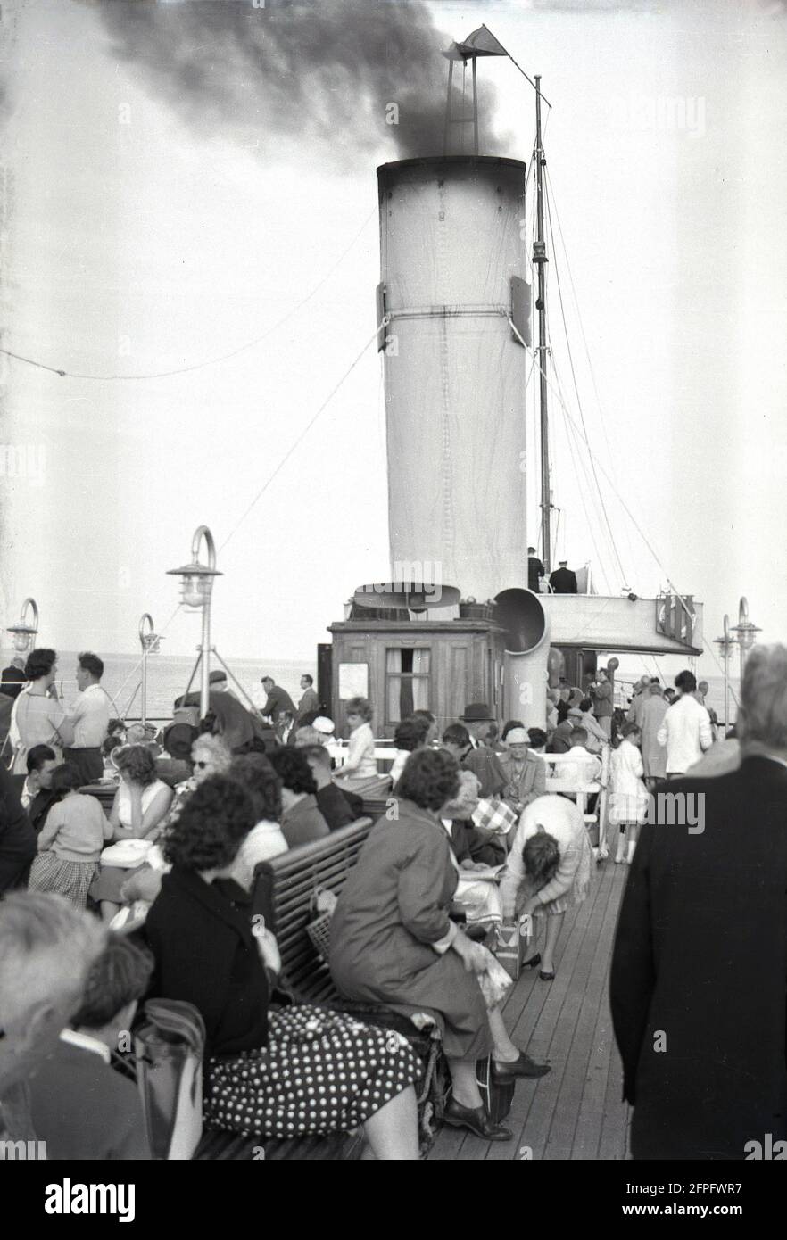 1962, historisch, Passagiere, die draußen sitzen, an Bord des Raddampfer, PS Medway Queen, Southend, England, Großbritannien. Sie wurde 1924 in Troon, Schottland, für den Einsatz an der Medway und der Themse-Mündung erbaut und spielte 1940 eine Rolle bei der Rettung britischer Soldaten aus Dunkirk. Nach WW2 sollte sie zerbrochen werden, wurde aber 1946 wieder aufgebaut und machte 1963 ihr letztes Segeln. 1966 wurde sie ein Nachtclub auf der Isle of Wright. Im Jahr 1980s wurde die Medway Queen Preservation Society gegründet, um dieses historische Schiff zu erhalten. Stockfoto