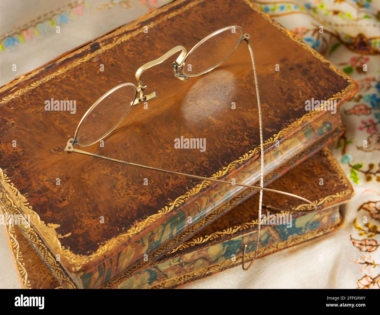 Antike goldumrandte Brillen auf Lederbüchern. Stockfoto