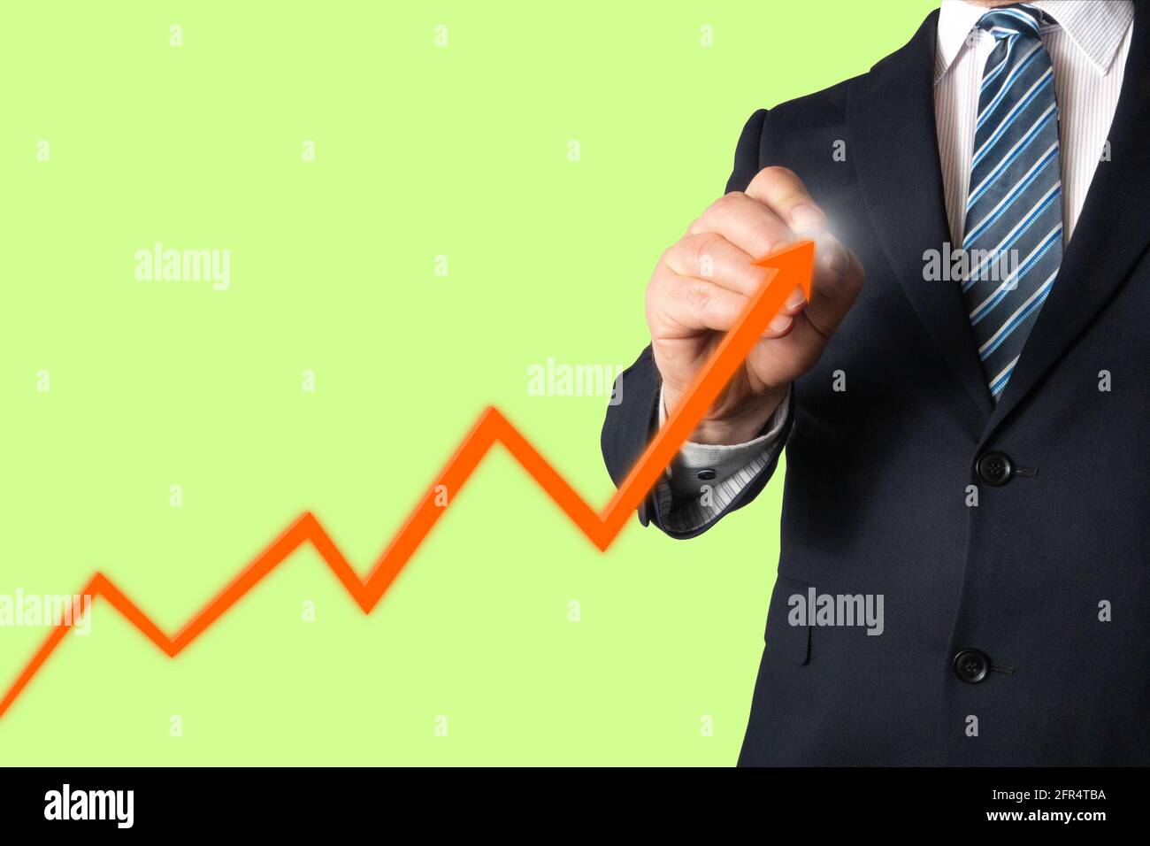 Geschäftsmann, der ein Diagramm zeichnet, in dem das wachsende oder prognostizierte Umsatzvolumen, die Nachfrage oder der Aktienwert dargestellt werden. Stockfoto