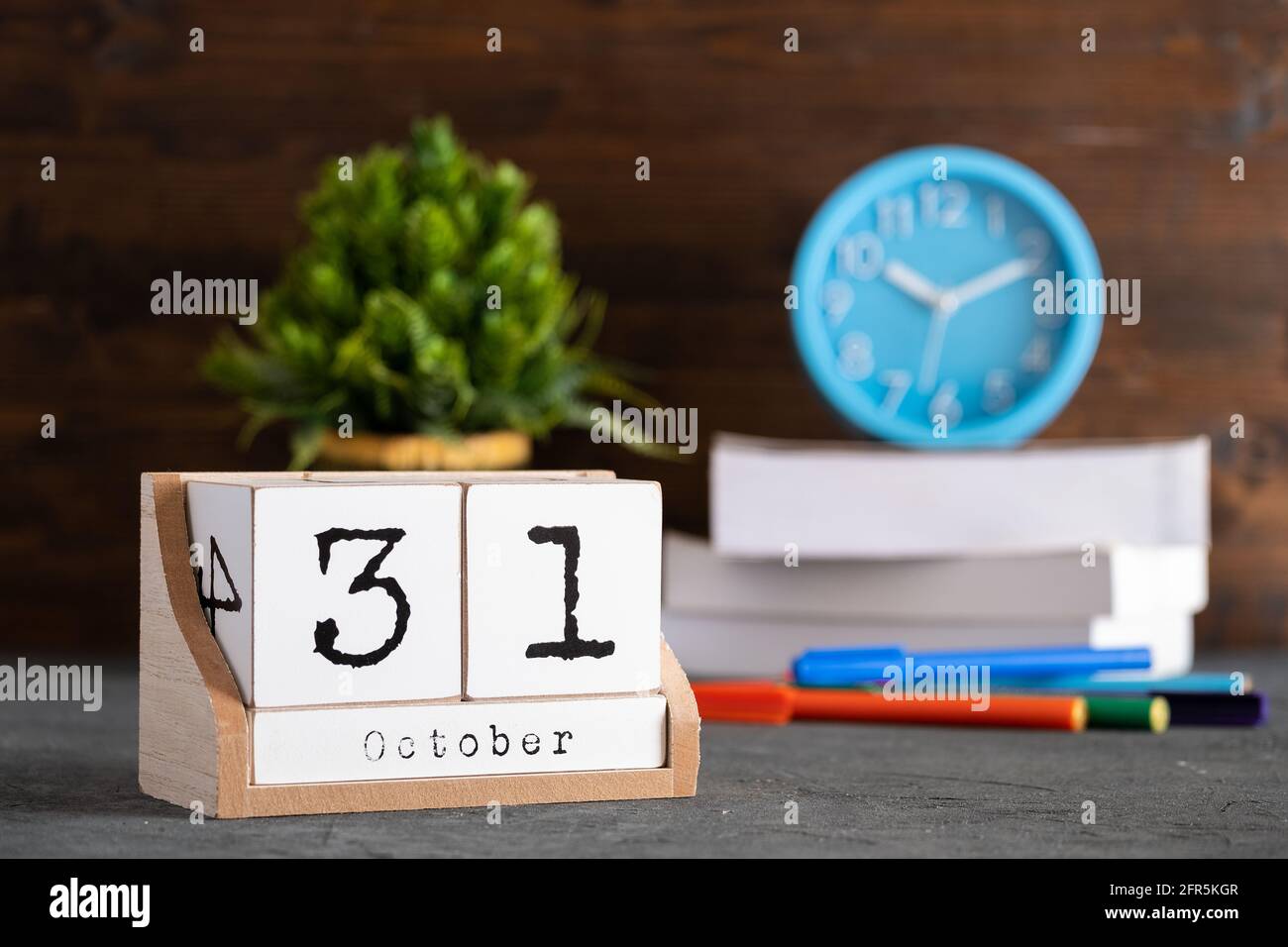 Oktober. Oktober 31 Holzwürfelkalender mit unscharfen Objekten auf dem Hintergrund. Stockfoto