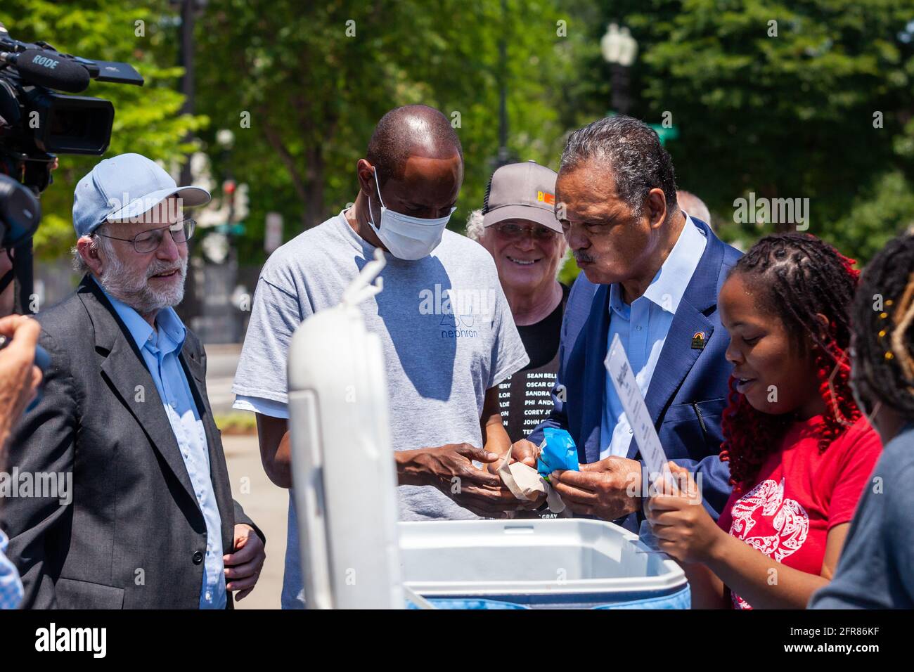Washington, DC, USA. Mai 2021. Im Bild: Rev. Jesse Jackson (Mitte rechts) genießt ein Eis-Sandwich mit Jerry Greenfield (links) und Ben Cohen (Mitte hinten), Mitbegründern von Ben & Jerry's Ice Cream, während seines überraschenden Besuches bei einer Veranstaltung, die ein Ende der qualifizierten Immunität für die Polizei fordert. Kredit: Allison Bailey/Alamy Live Nachrichten Stockfoto