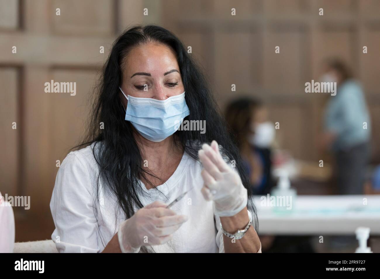 Seattle, Washington, USA. Mai 2021. Kimberly McLeod, eine Krankenschwester mit 6M Geriatrie und Krankenhausmedizin, bereitet eine Dosis des Coronavirus-Impfstoffs in einer Gemeinschaftsklinik in der St. Mark's Episcopal Cathedral im Viertel Capitol Hill in Seattle zu. Außer Sichtweite spielt die Gemeindemitglied Cara Peterson das historische Flentrop-Organ der Kathedrale, um Patienten und Kliniker zu beruhigen. Quelle: Paul Christian Gordon/Alamy Live News Stockfoto