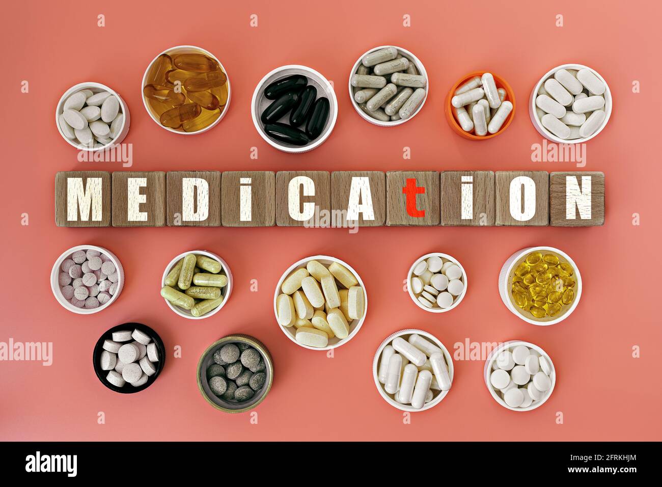 Foto zum Thema Medikamente. Holzwürfel mit der Aufschrift 'medication', und biologisch aktive Nahrungsergänzungsmittel, auf Korallen-Hintergrund Stockfoto