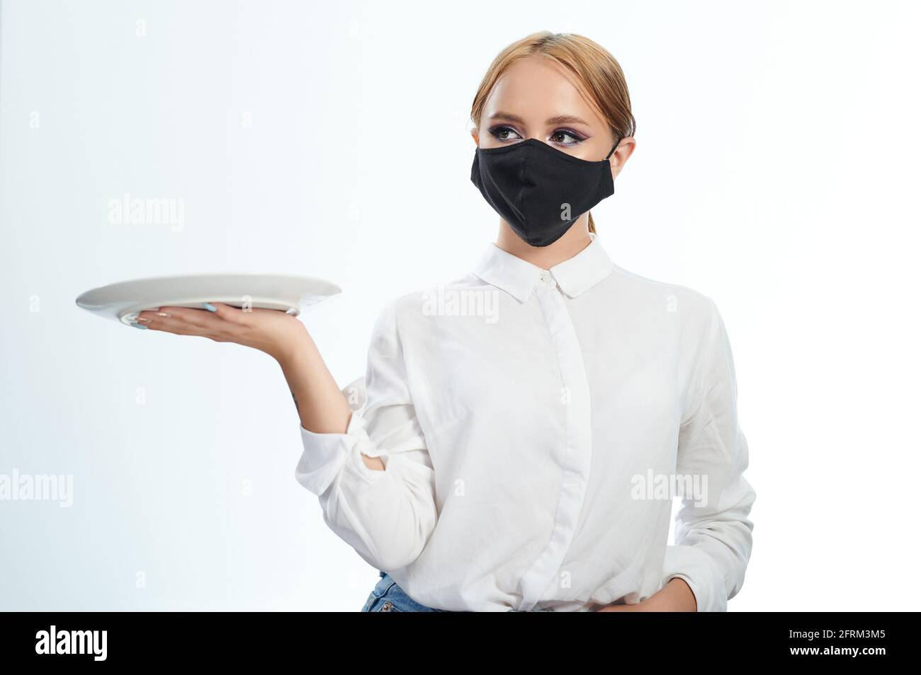 Kellnerin mit Teller auf der Hand isoliert auf weißem Studio Hintergrund Stockfoto