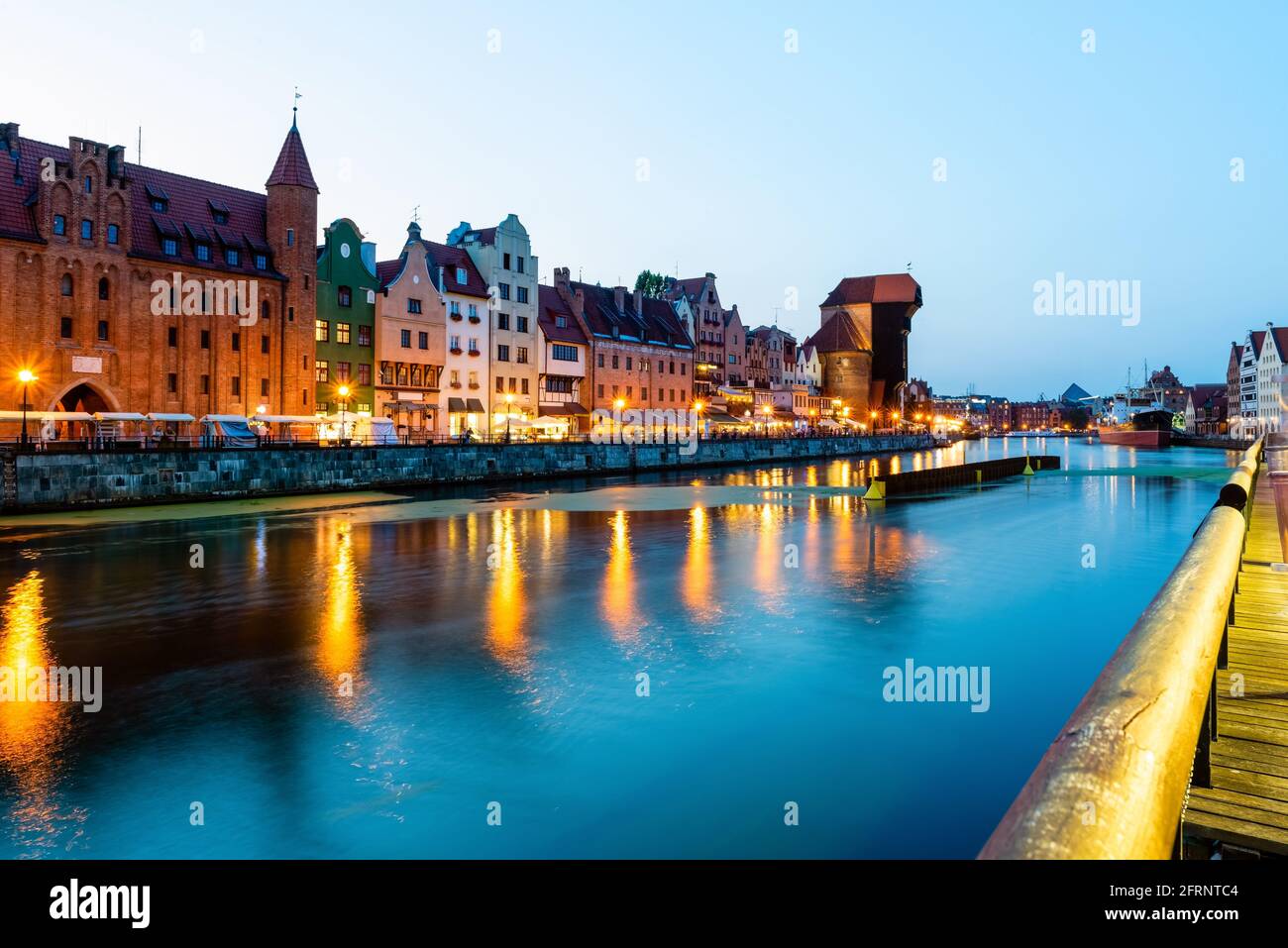 Blick auf die Stadt Danzig bei Nacht am Fluss. Blick auf den berühmten Kran und die Fassaden der alten mittelalterlichen Häuser an der Promenade in Danzig Stadt. Polen. Stockfoto