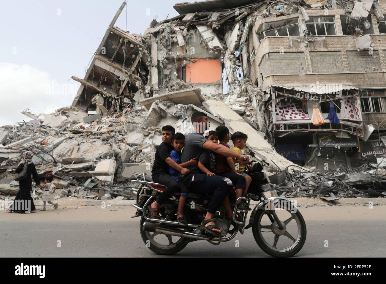 Palästinenser fahren mit dem Motorrad am Ort eines israelischen Luftanschlags vorbei, nach dem Waffenstillstand der Hamas in Gaza am 21. Mai 2021. REUTERS/Suhaib Salem Stockfoto