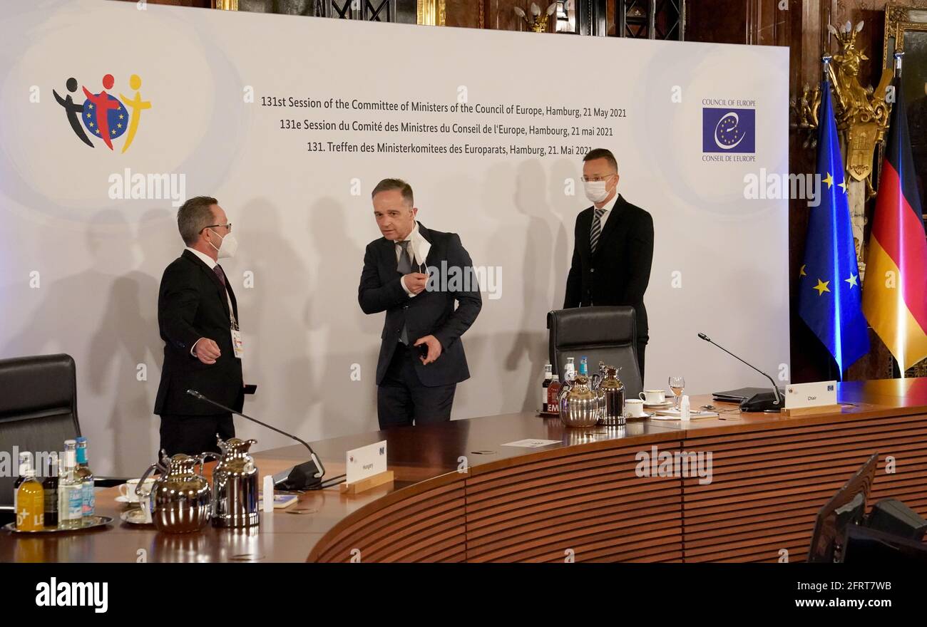 21. Mai 2021, Hamburg: Bundesaußenminister Heiko Maas (M, SPD) geht mit dem ungarischen Außenminister Peter Szijjarto (r) zur 131. Sitzung des Ministerkomitees des Europarates im Kaisersaal im Hamburger Rathaus. Bei der Sitzung wird der sechsmonatige Vorsitz des Ministerkomitees des Europarates von Deutschland an Ungarn übergeben. Der Europarat, der seinen Sitz in Straßburg hat, arbeitet mit seinem Gerichtshof zusammen, um die Menschenrechte in seinen 47 Mitgliedstaaten zu wahren. Foto: Marcus Brandt/dpa-Pool/dpa Stockfoto