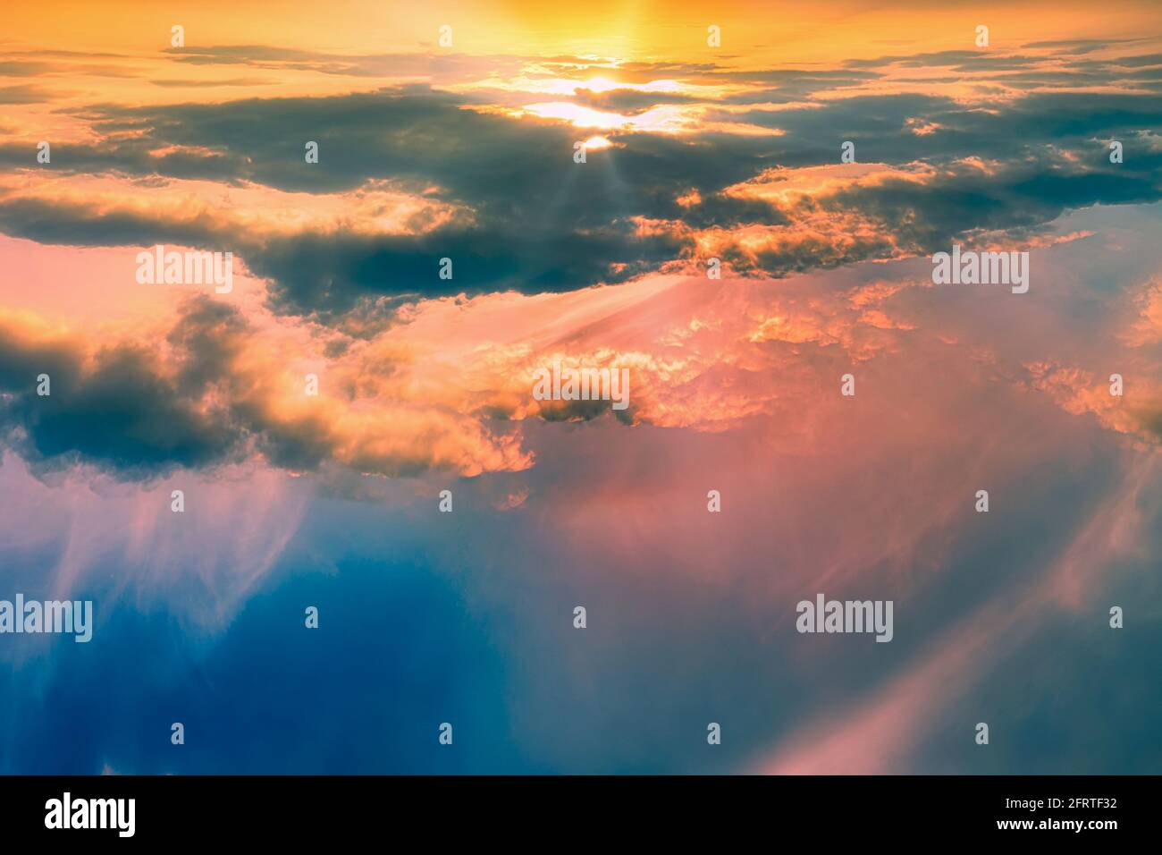Das Salz erhebt sich über den rosa und orange Wolken - eine sanfte Märchendämmerung - Morgenröte zwischen hellen feurigen Wolken in großer Höhe. Abstrakte Fotografie. Stockfoto