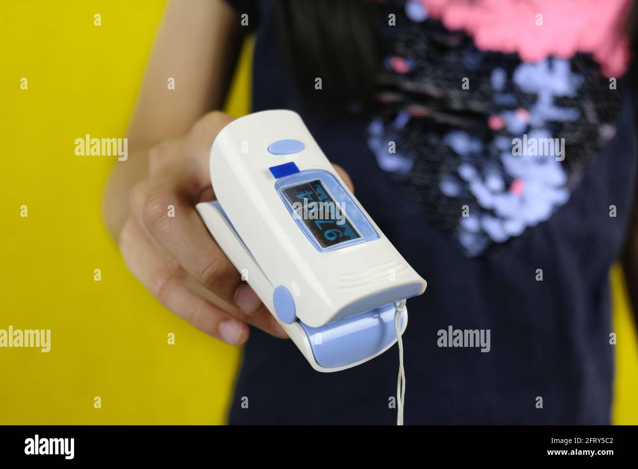 Ein Nahaufnahme Bild eines Mädchens, das ein digitales Bild einlegt Oximeter an der Fingerspitze, um den Sauerstoffgehalt in zu messen Ihr Blut, um auf mögliche Covid-19-Infe zu überprüfen Stockfoto