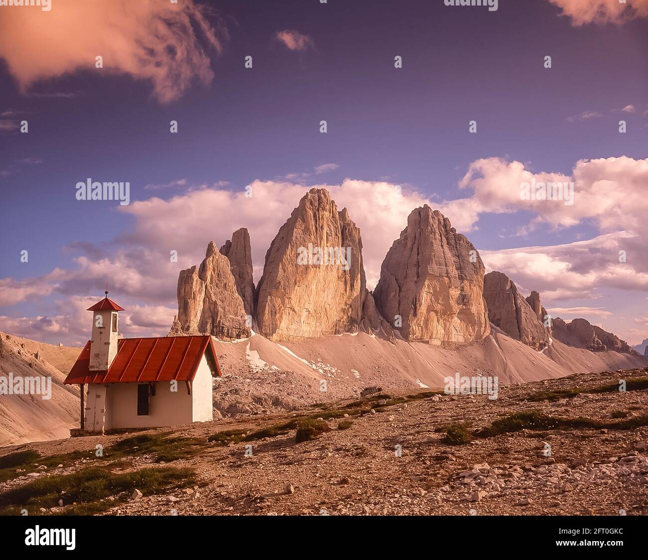 Italien. Das Bild zeigt die Kletterkapelle auf der drei Zinnen Hütte [Rifugio Locatelli], die auf die berühmten drei Türme blickt, die auf Deutsch drei Zinnen heißen, aber auf Italienisch poetischer Weise als die drei Zinnen di Laverado in der östlichen Region der italienischen Dolomiten in Sexten-Sexten genannt werden. Während des Ersten Weltkriegs, bekannt als der Weiße Krieg, stellten die Gipfel eine natürliche Barriere zwischen den Italienern und den streikenden Österreichern dar, wobei die Front durch die Gipfel lief. Stockfoto