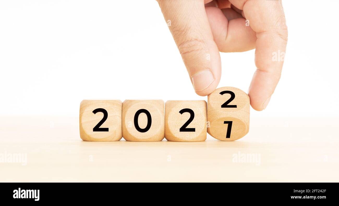 Handwechselnde Holzblöcke mit der Nummer 2021 bis 2022. Konzept für das neue Jahr. Speicherplatz kopieren. Weißer Hintergrund Stockfoto