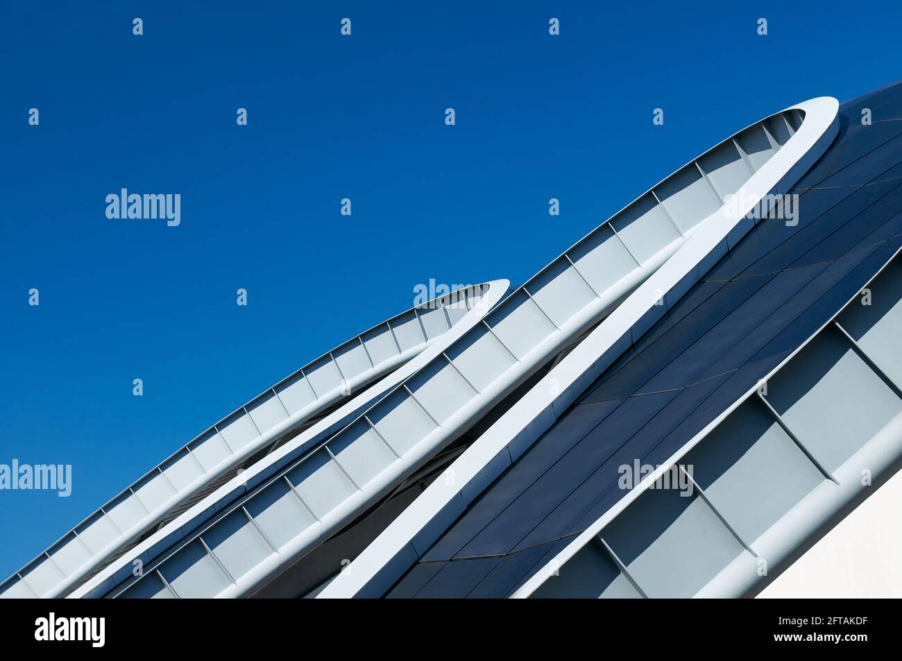 Gateshead, Großbritannien - 6. April 2019: Nahaufnahme der geschwungenen Stahldachlinie des Sage-Gebäudes in Gateshead, vor blauem Himmel. Stockfoto