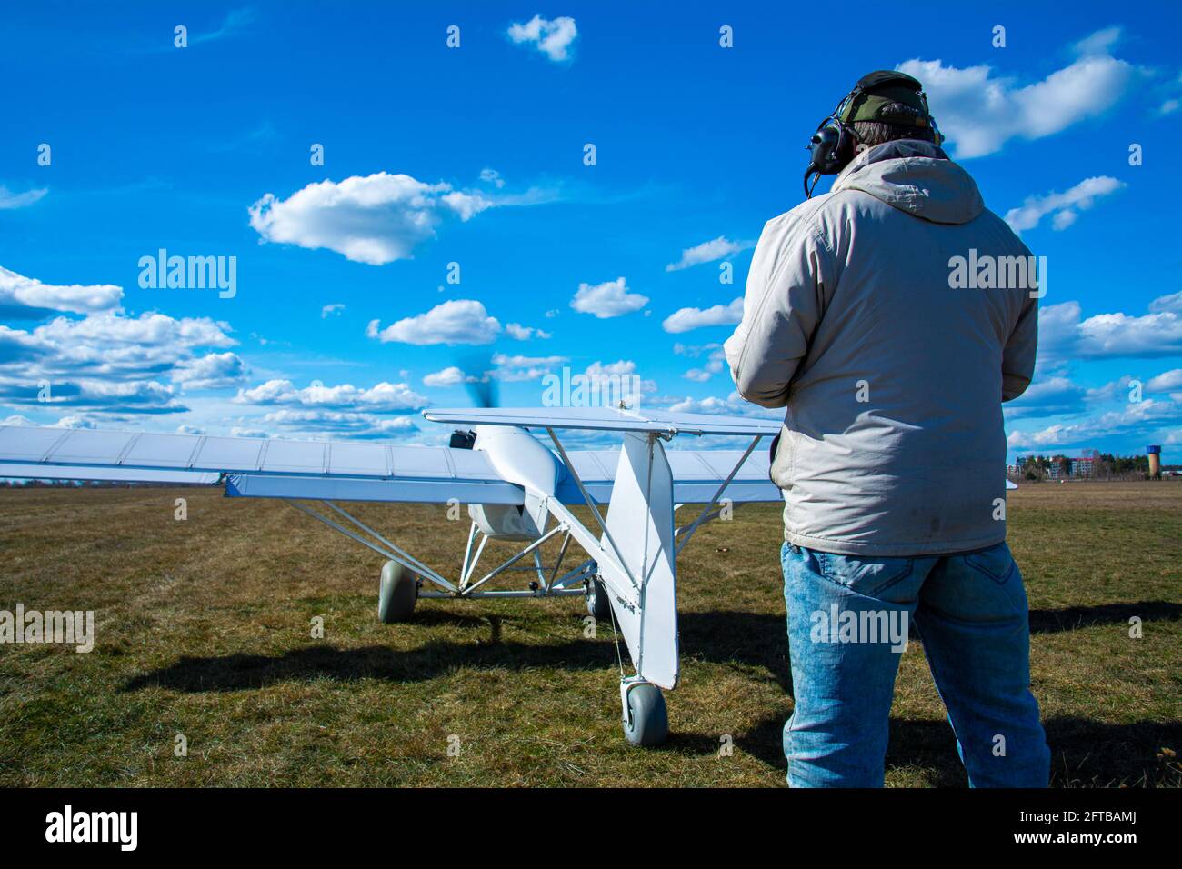 Ein Operator mit einem unbemannten Flugzeug auf der Start- und Landebahn. Ein Mann fliegt ein unbemanntes Flugzeug, das für den Einsatz in der Landwirtschaft entwickelt wurde. Stockfoto