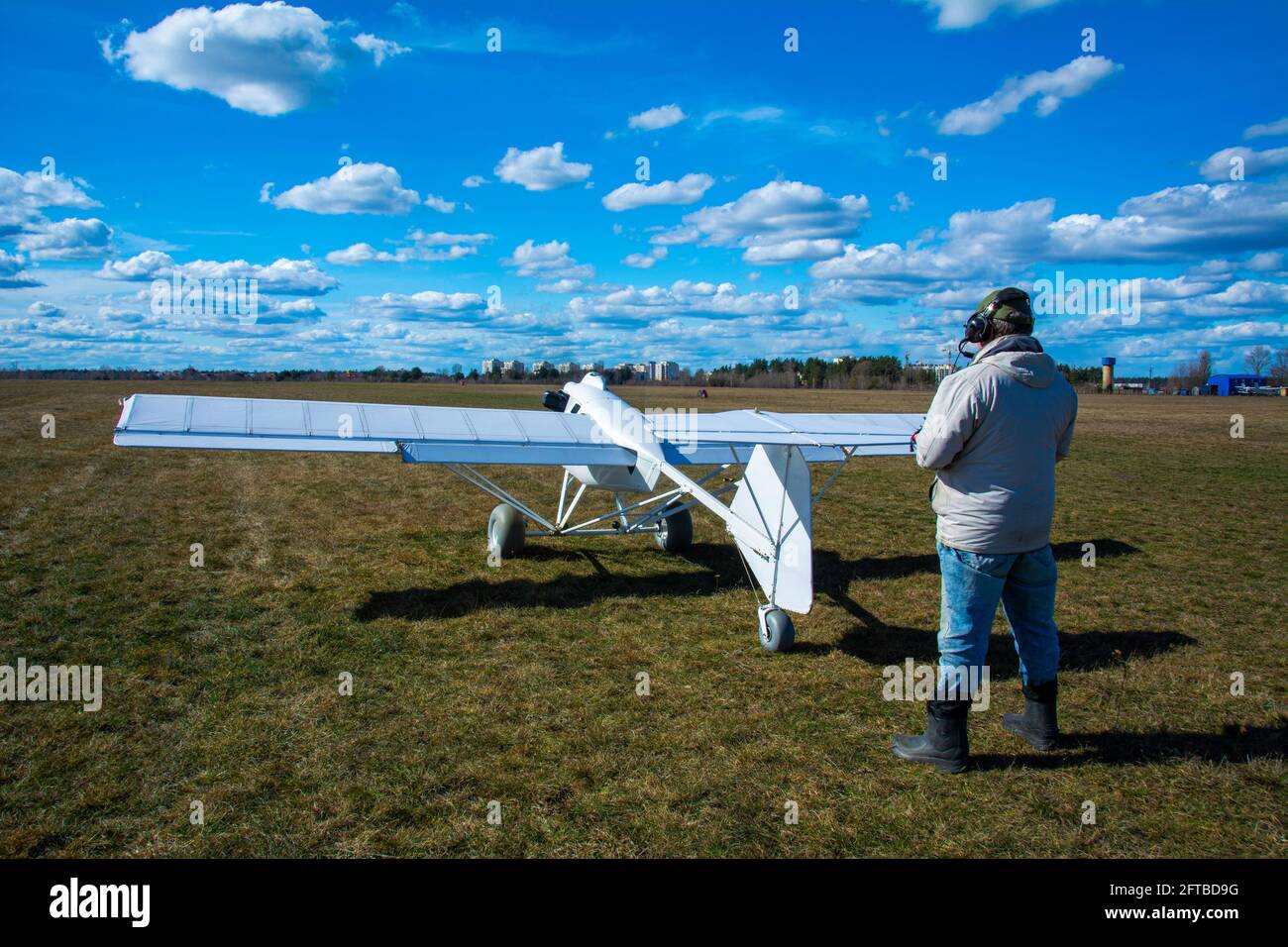 Ein Operator mit einem unbemannten Flugzeug auf der Start- und Landebahn. Ein Mann fliegt ein unbemanntes Flugzeug, das für den Einsatz in der Landwirtschaft entwickelt wurde. Stockfoto