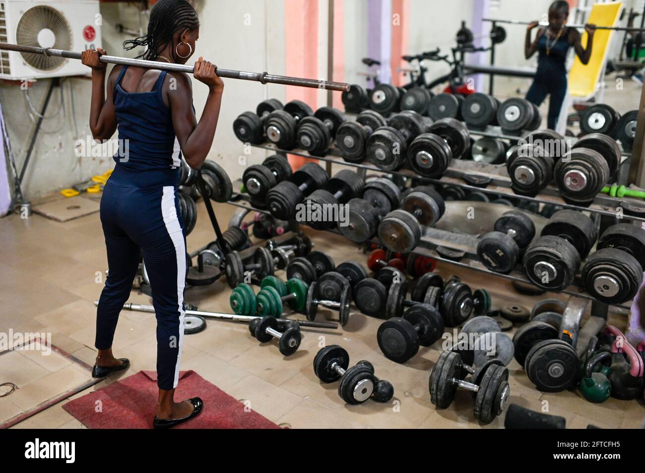 SENEGAL, Thies, Gym, Fitness and Body Building Studio, junge Frau beim Training mit Gewichtheben / junge Frau im Fitness Studio, Training mit Gewichten heben Stockfoto