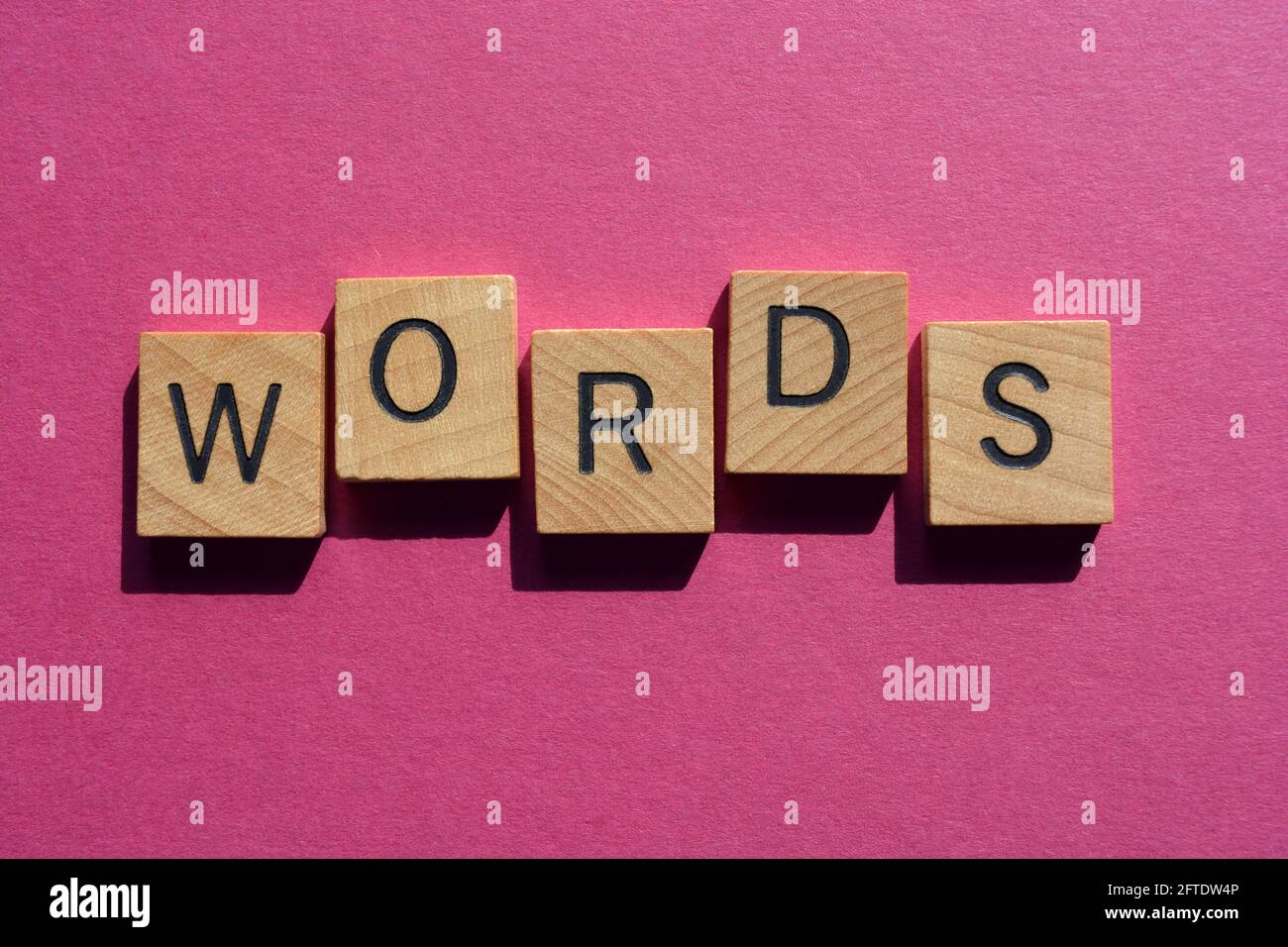 Wörter, Wort in hölzernen Buchstaben, isoliert auf rosa Hintergrund als Banner-Überschrift Stockfoto