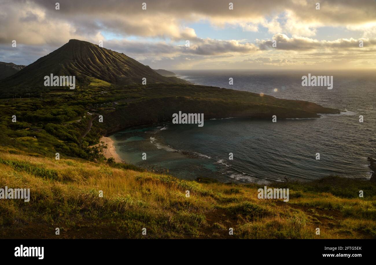 Ruhiger, ruhiger Sonnenaufgang über der Hanauma Bay, einem der beliebtesten Reiseziele für Schnorcheln und Schwimmen, und dem Koko Head Crater, Oahu, Honolulu, Hawaii, USA Stockfoto