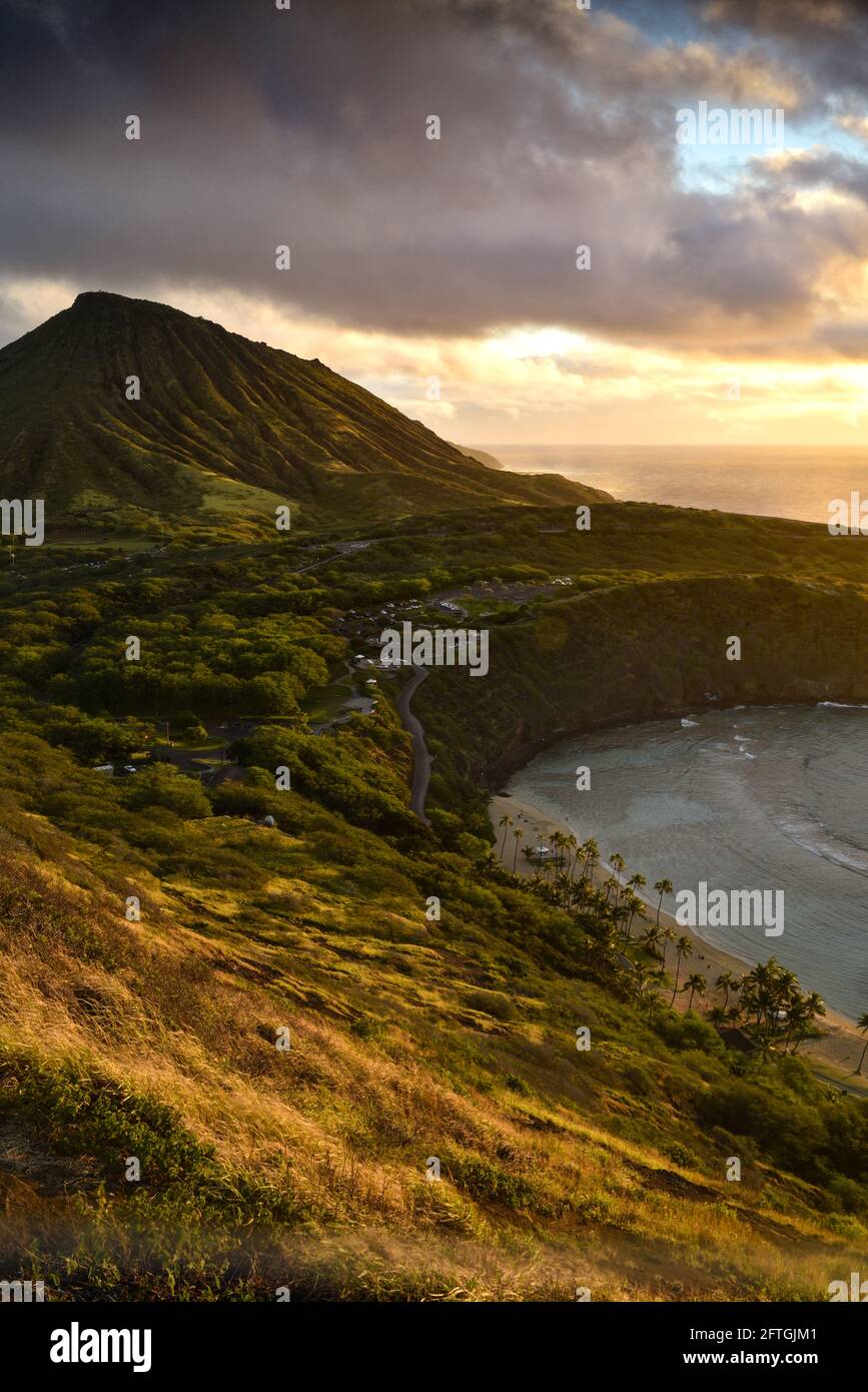 Ruhiger, ruhiger Sonnenaufgang über der Hanauma Bay, einem der beliebtesten Reiseziele für Schnorcheln und Schwimmen, und dem Koko Head Crater, Oahu, Honolulu, Hawaii, USA Stockfoto