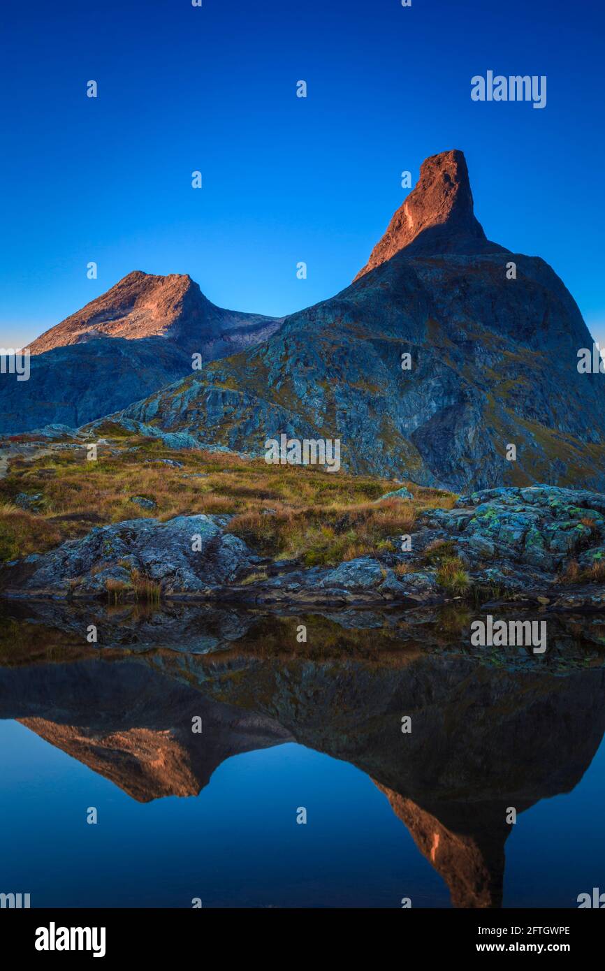 Frühmorgendliche Herbstsonne auf dem Berg Olaskarstinden (links) und Romsdalshorn (rechts) in Romsdalen, Rauma kommune, Møre Og Romsdal, Norwegen. Stockfoto