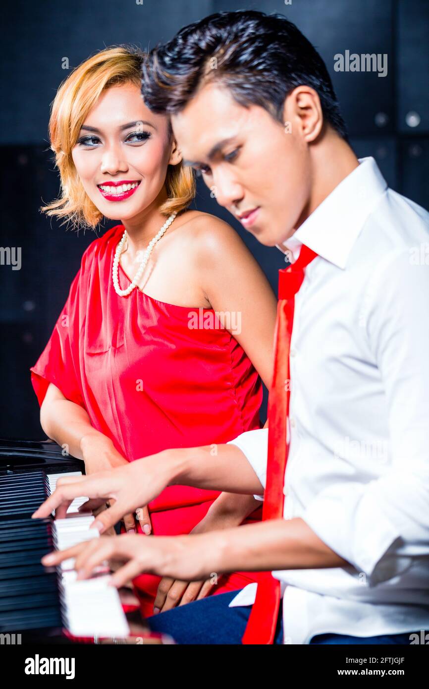 Asiatische professionelle Sängerin und Pianistin arbeiten und diskutieren über neue Songs im Studio zu komponieren und aufnehmen Stockfoto