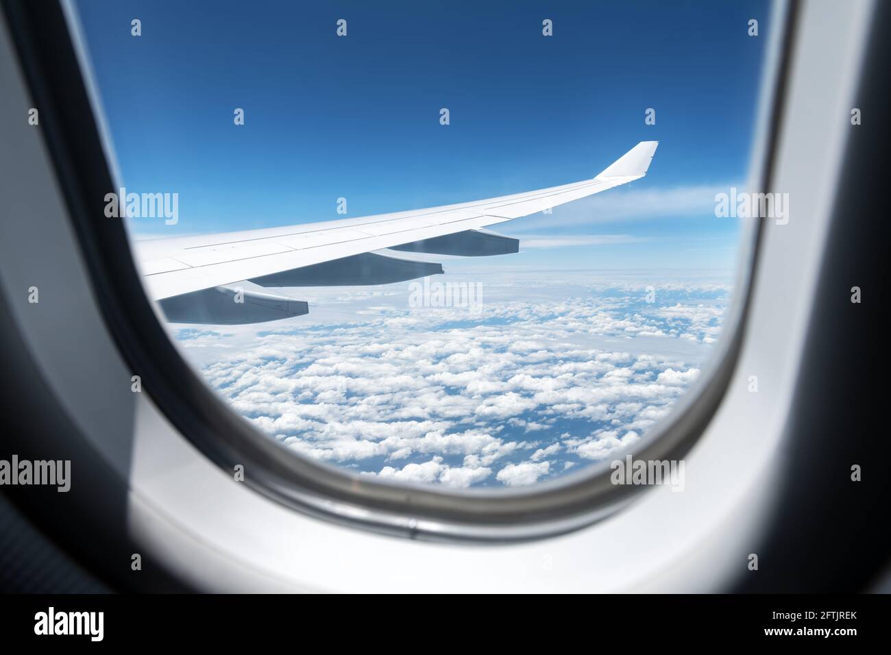Blick auf Wolken und Flügel aus einem Flugzeugfenster Stockfoto